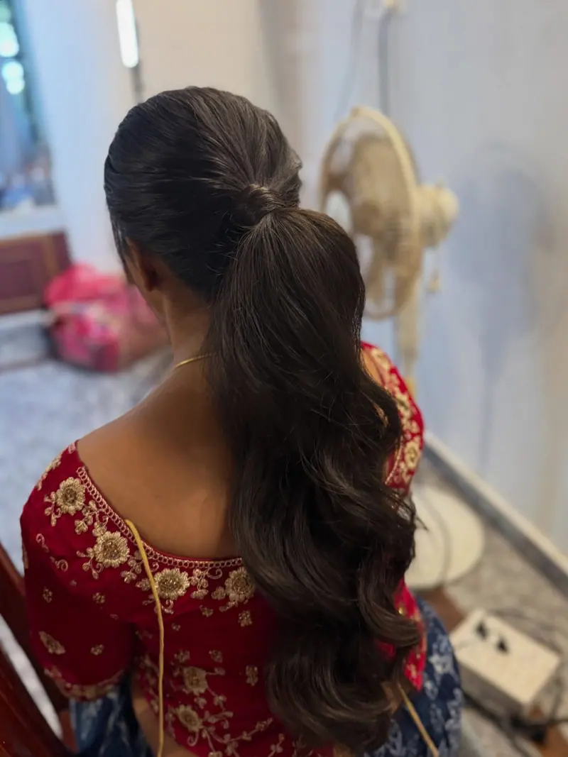High ponytail with soft waves on a red embroidered blouse