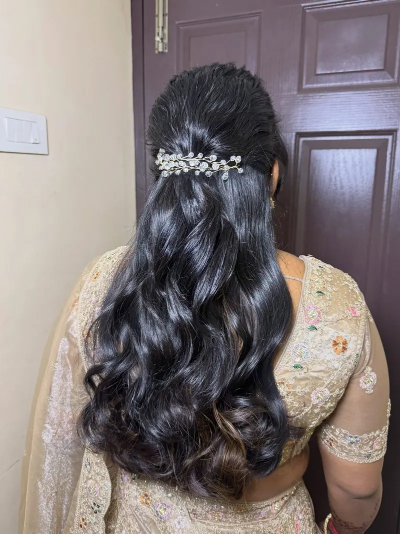 Voluminous bridal curls with a pearl hair accessory, back view