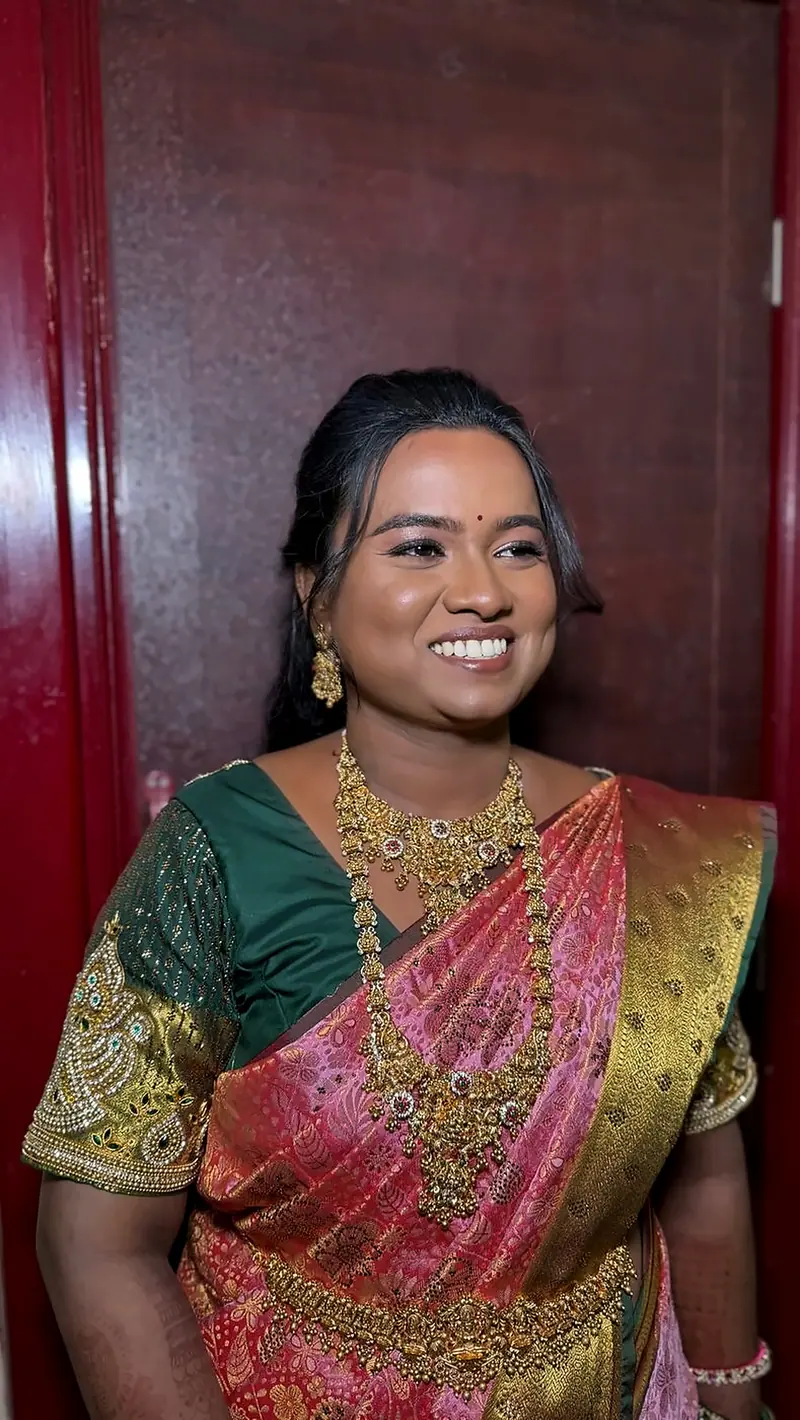 Bride in pink and green silk saree with gold jewellery