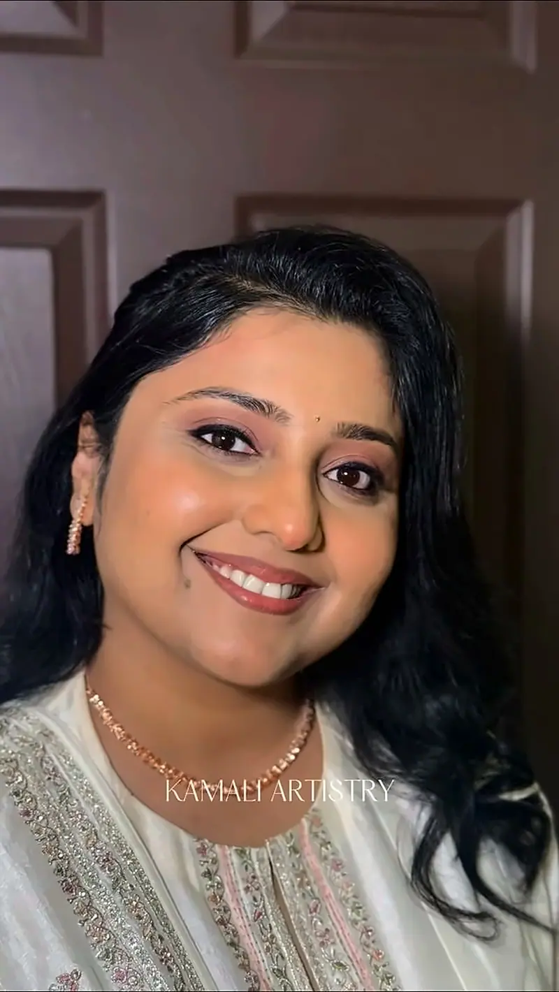 Smiling woman with voluminous curls and glowing party makeup