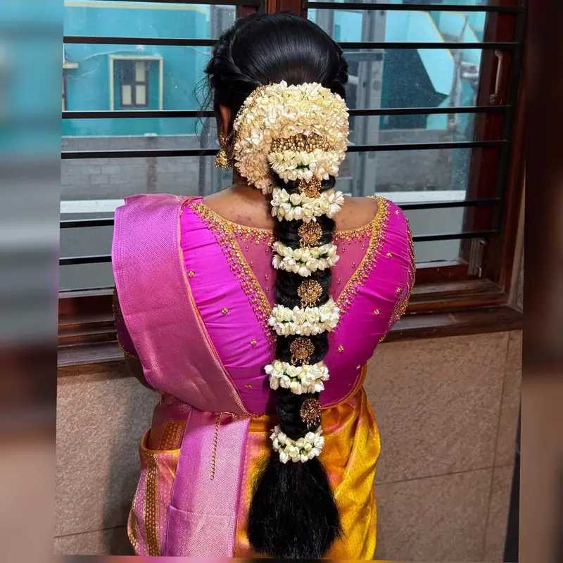 Bridal braid heavy with jasmine flowers in pink and orange silk, back view