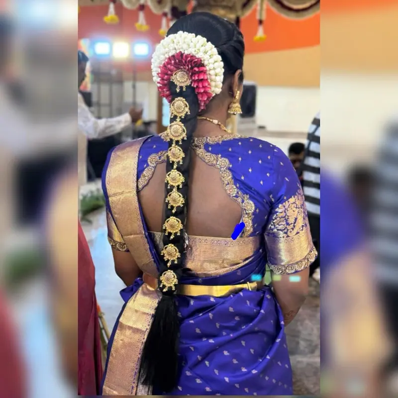 Jasmine-flower braid with gold ornaments over a royal blue silk blouse, back view