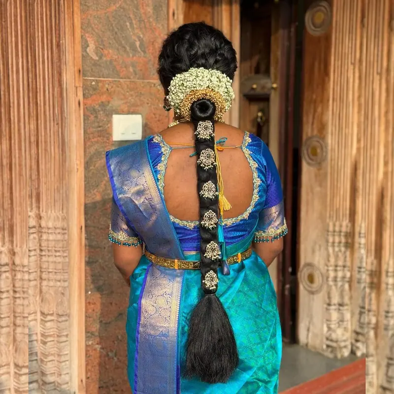 Jasmine braid on a woman in a teal silk saree, back view