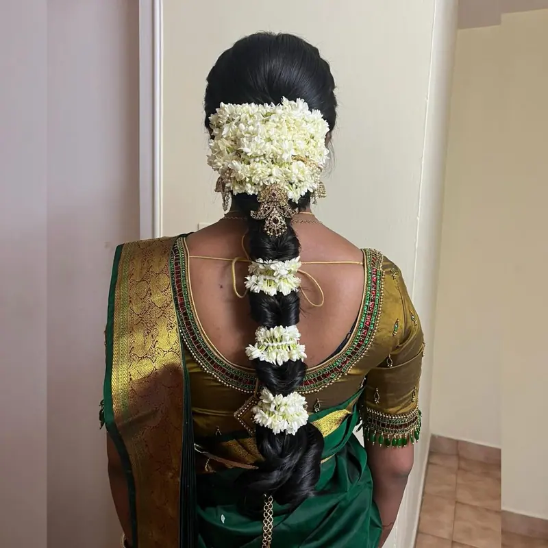 Traditional jasmine braid on a green silk blouse, back view