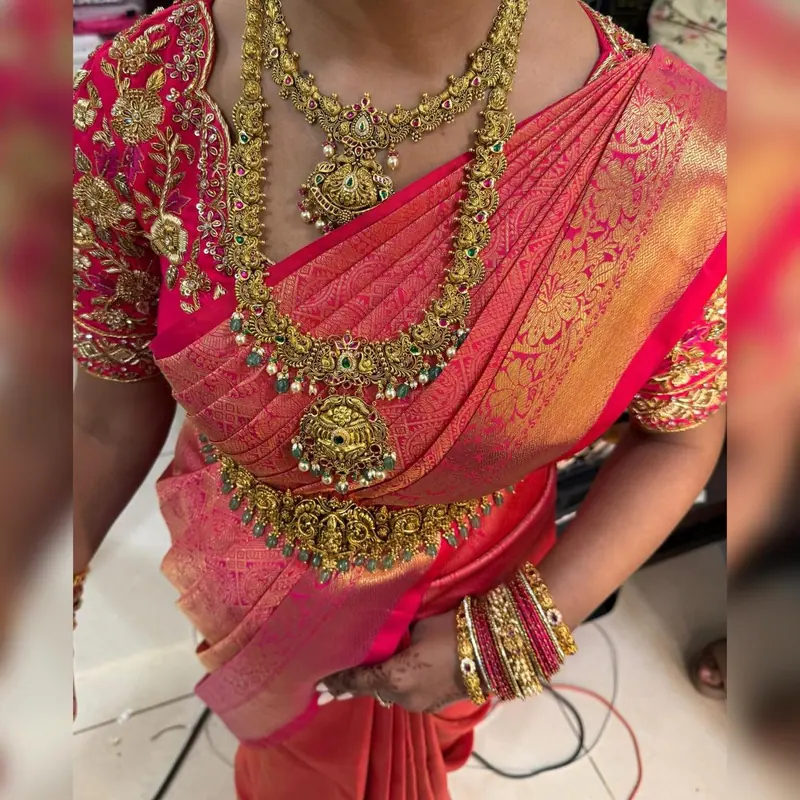 Detail of a pink silk saree with gold temple jewellery