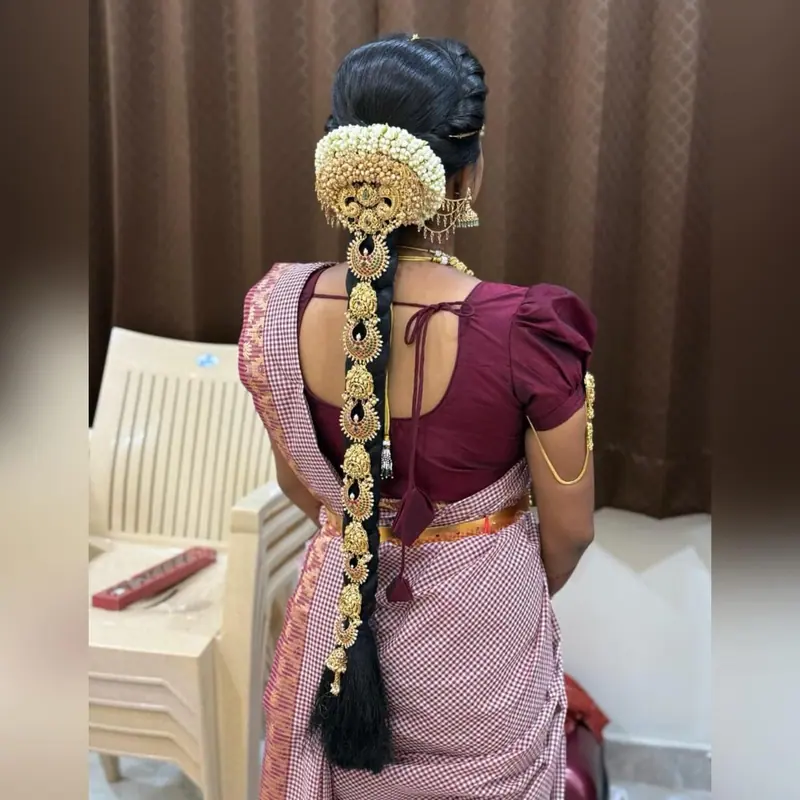 Jasmine floral braid with gold ornament over a pink saree, back view