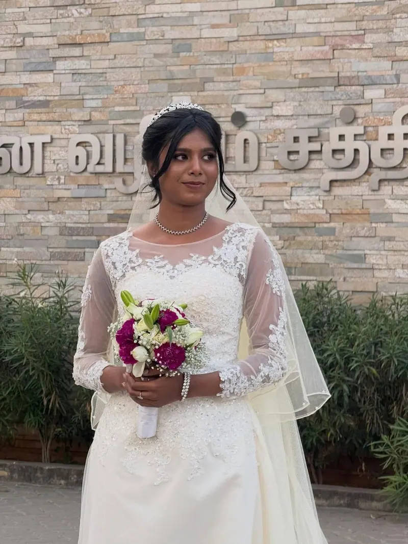 Bride in a white lace gown with a bouquet and veil