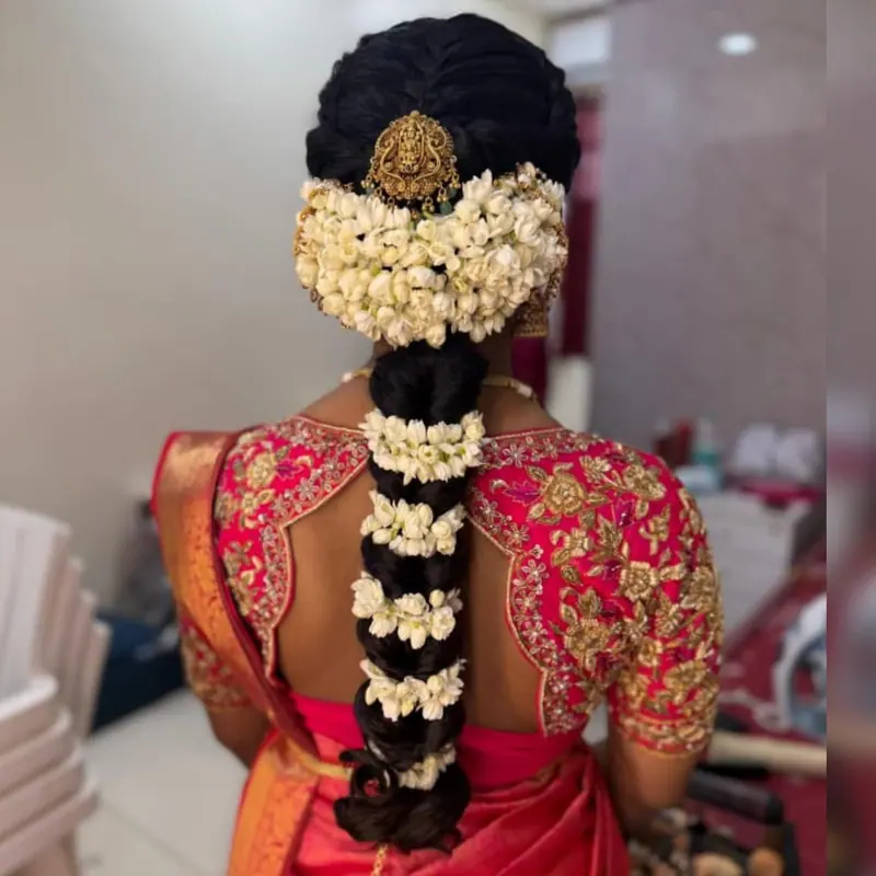 Heavy jasmine bridal braid on a red embroidered blouse, back view