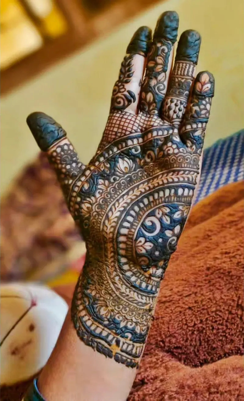 Intricate mehandi design on the palm and fingers