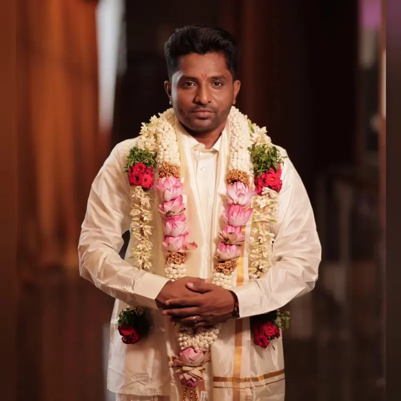 Groom in a dhoti with flower garlands at the wedding